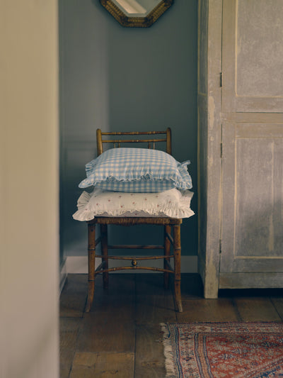 Chair with checkered and patterned cushions against a blue wall