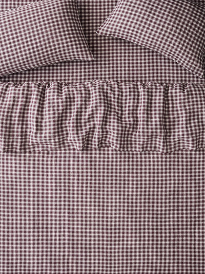 Brown and white gingham check bedding set including a sheet, pillowcases, and a ruffled bed skirt.