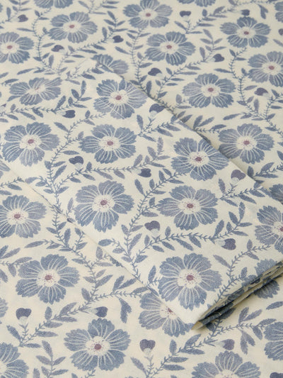 Roll of fabric with blue floral pattern on a beige background