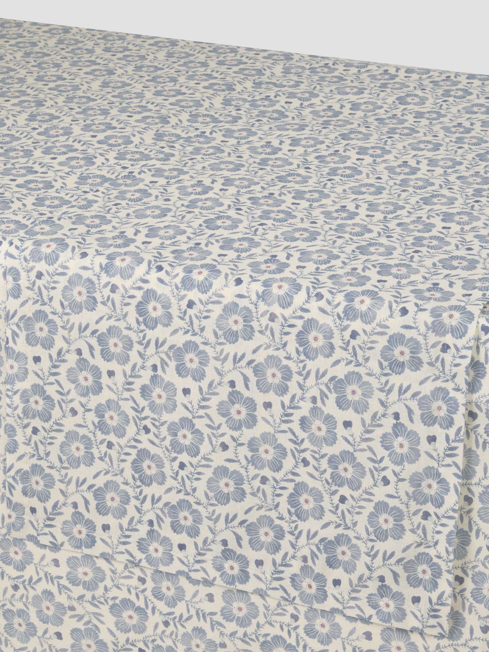 Floral patterned fabric with small blue flowers on a light background