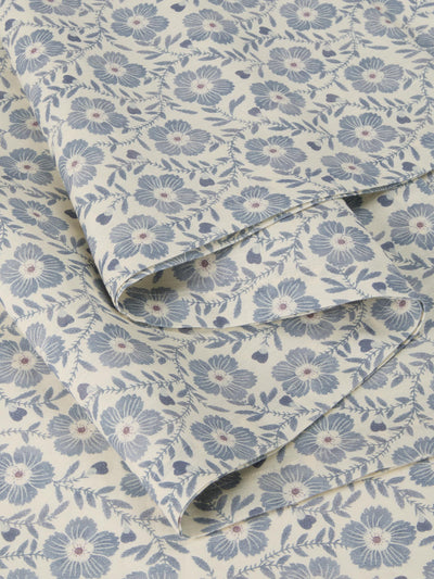 Roll of fabric with a blue floral pattern on a beige background