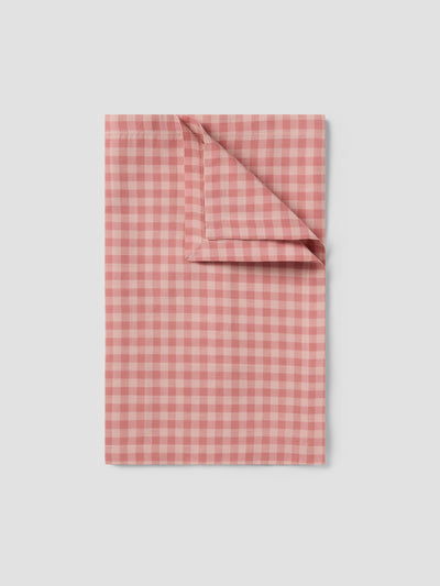 Folded pink and white checkered fabric on a light gray background