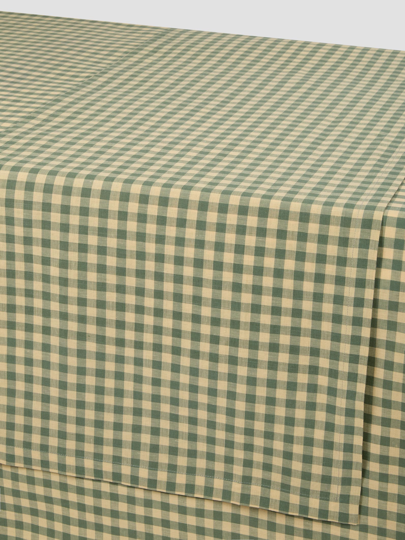 Green and beige checkered fabric on a white background