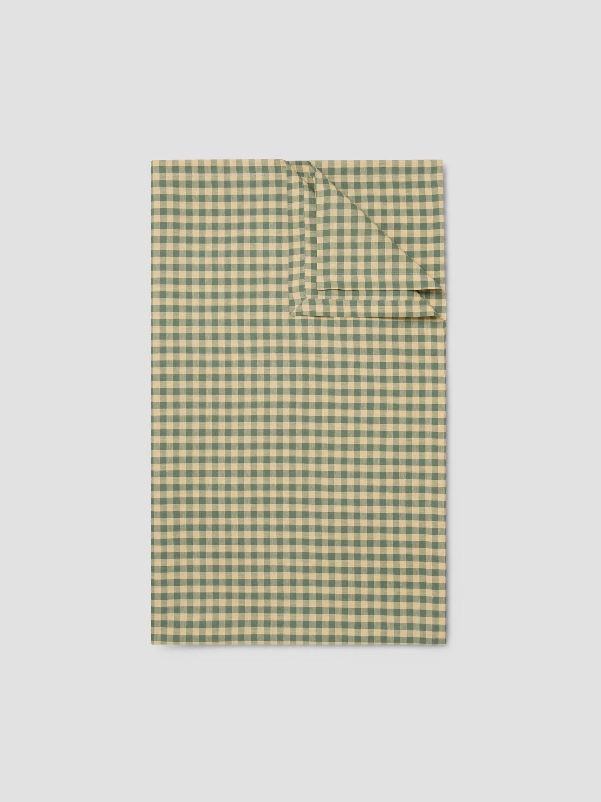 Green and yellow checkered shirt on a light gray background