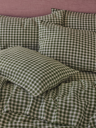 Green and white gingham check bedding set including a duvet cover and matching pillowcases, styled on a bed against a dusty pink headboard.