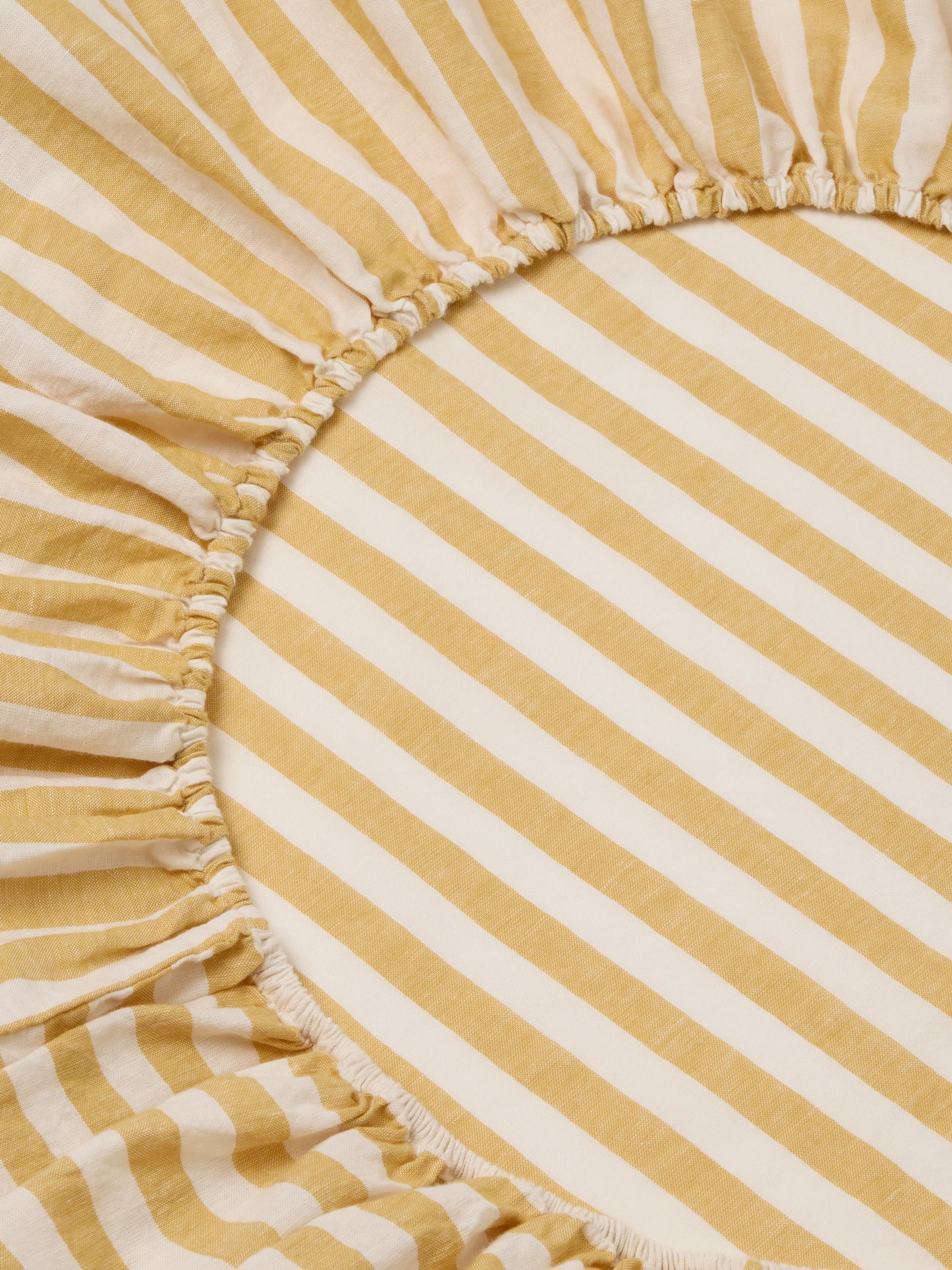 Close-up of a yellow and white striped fabric with ruffled edges.