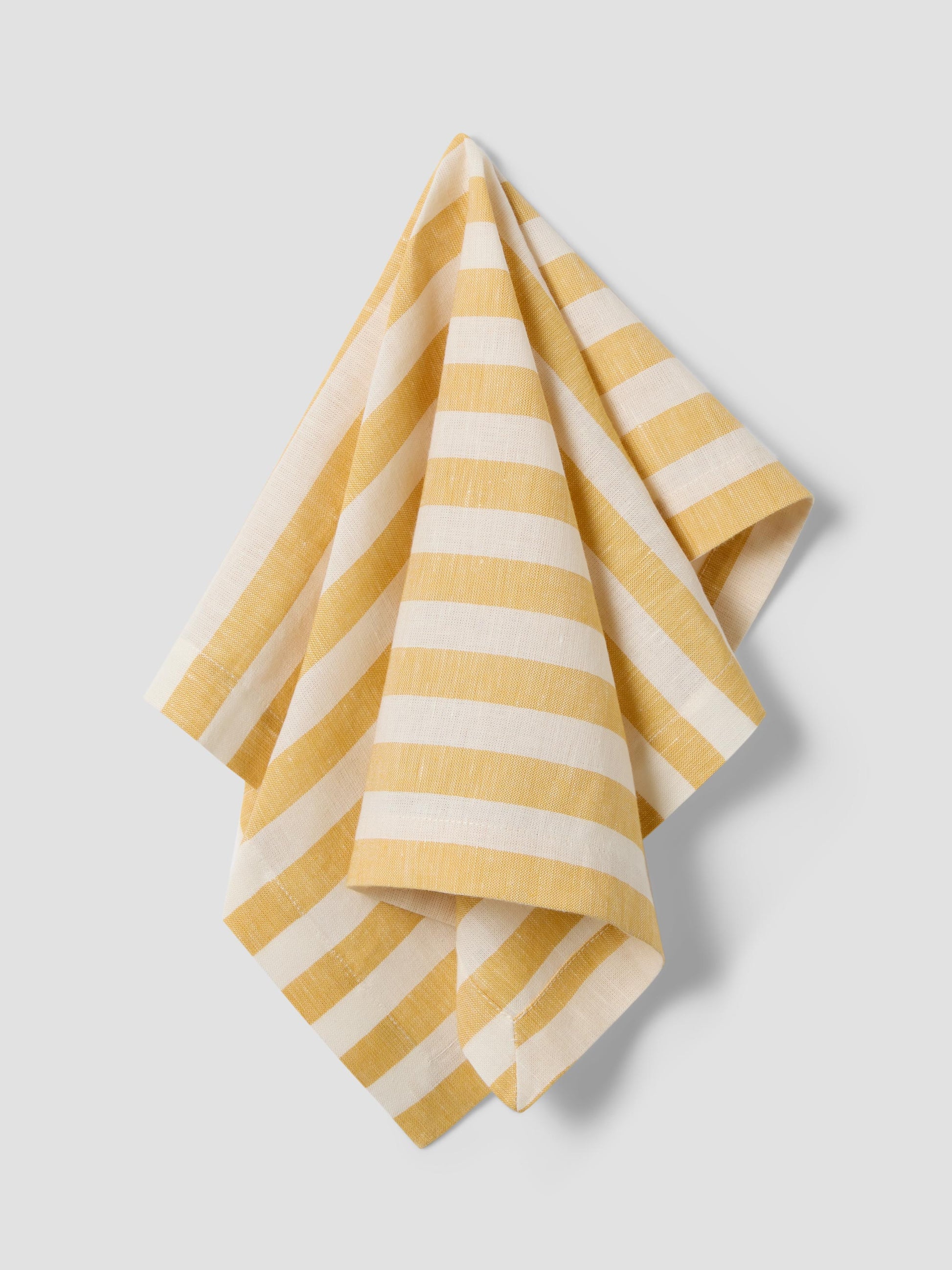 Yellow and white striped napkin on a light gray background