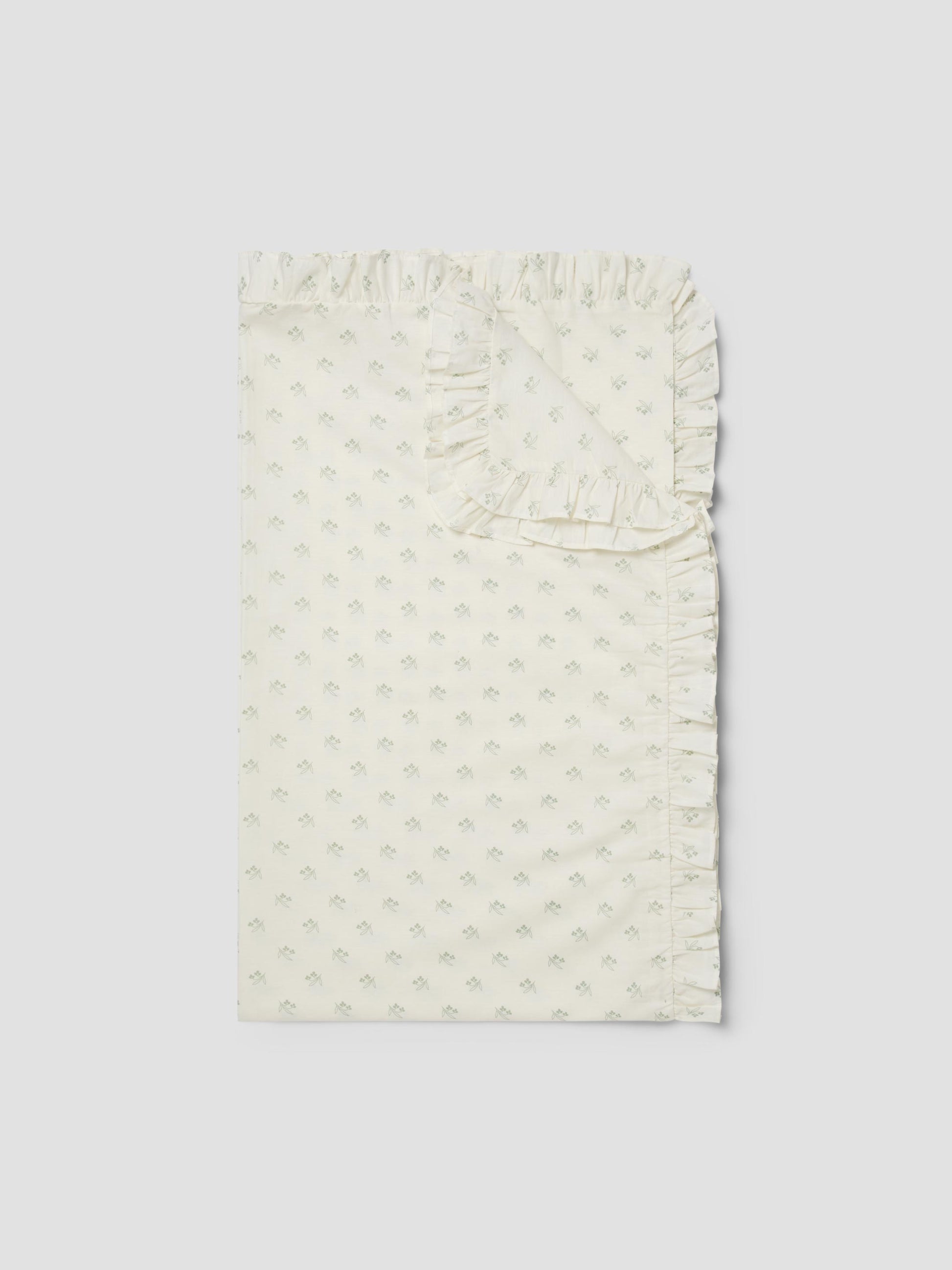 White textured fabric with ruffled edge on a light gray background