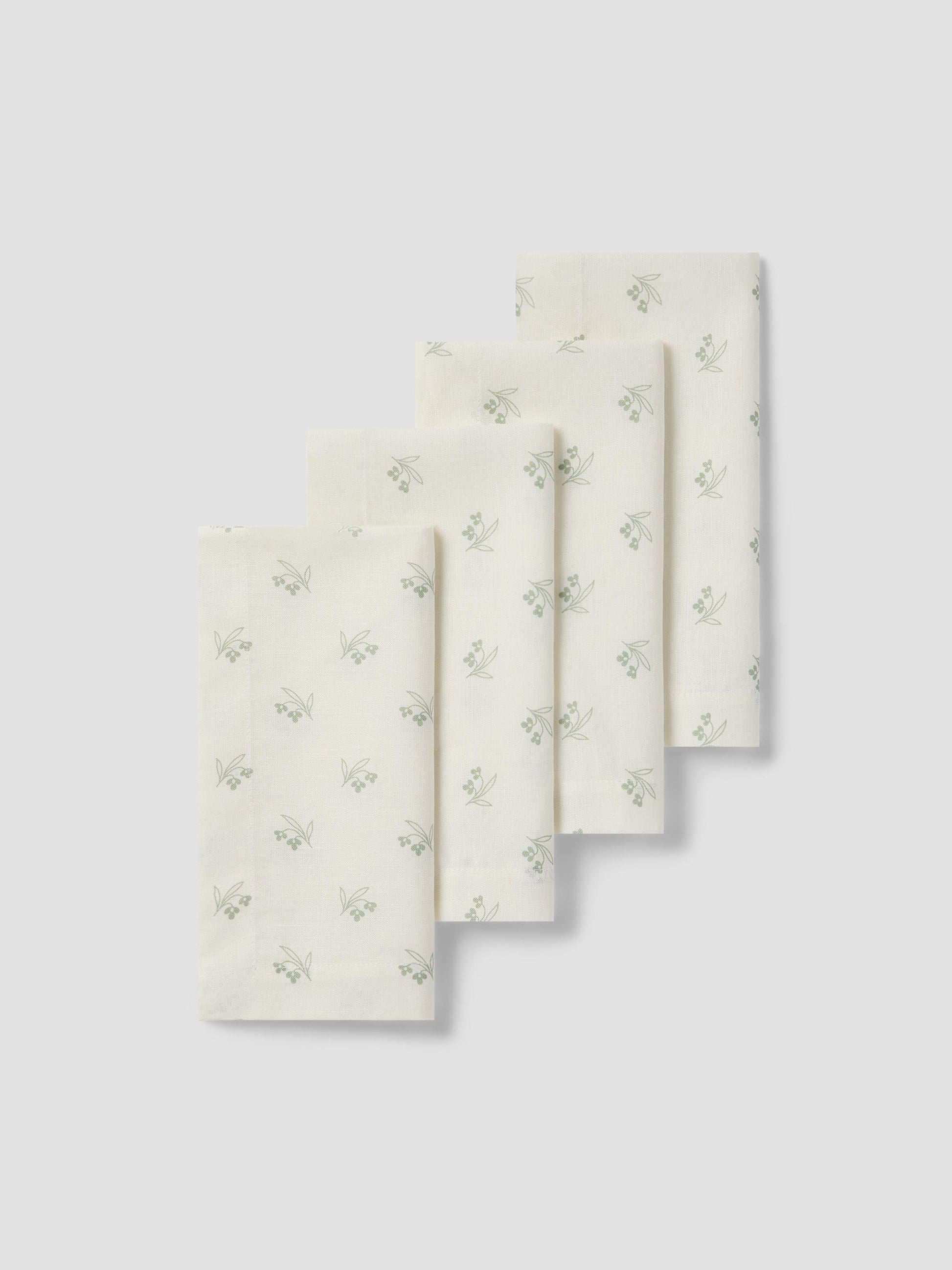 Set of three folded towels with a subtle green floral pattern on a light gray background