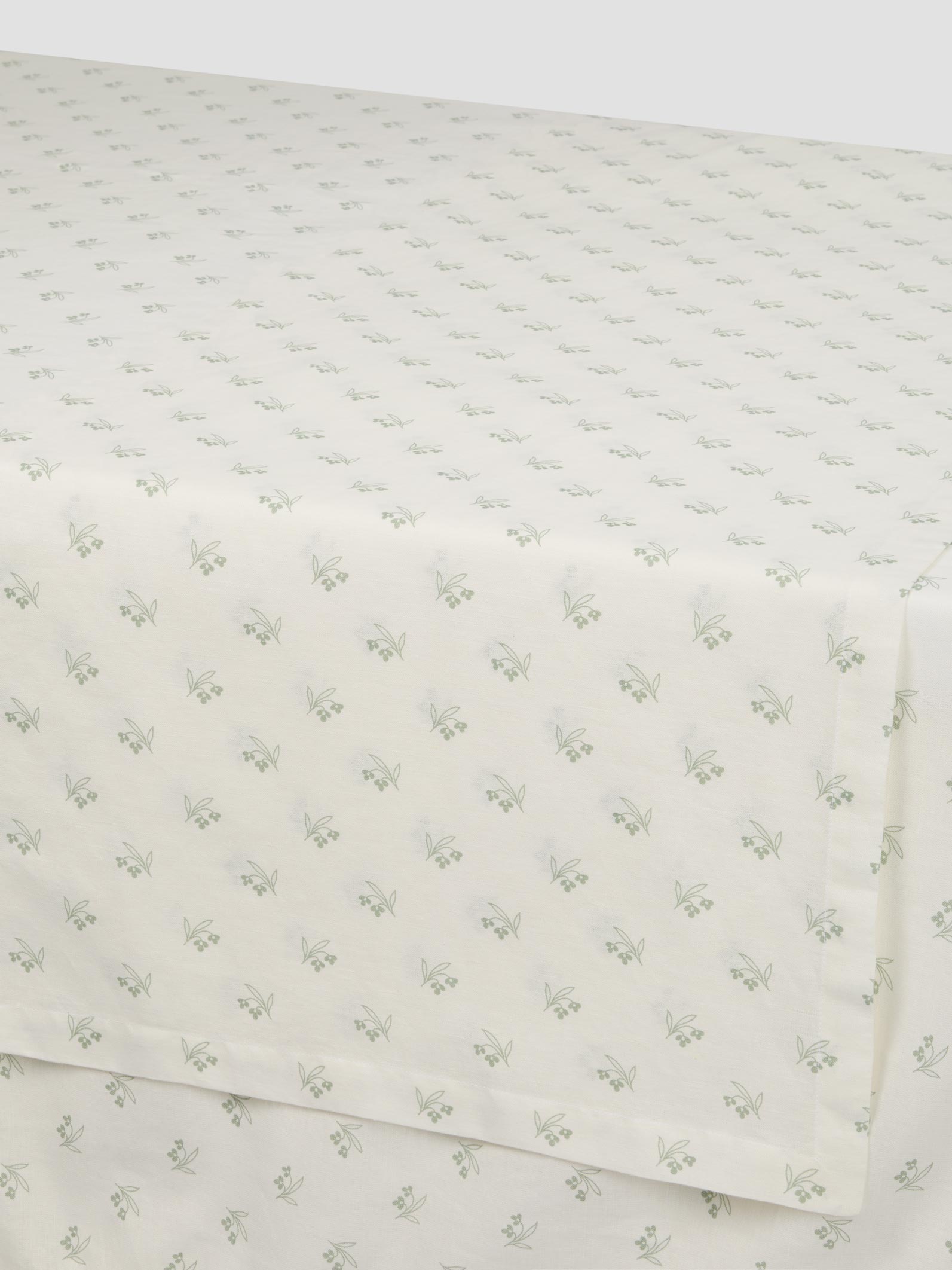 White fabric with green floral pattern on a white background