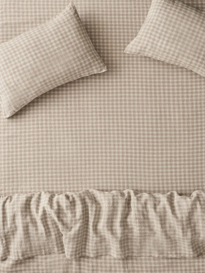 Beige and white gingham check bedding set with two pillows and a ruffled duvet cover.