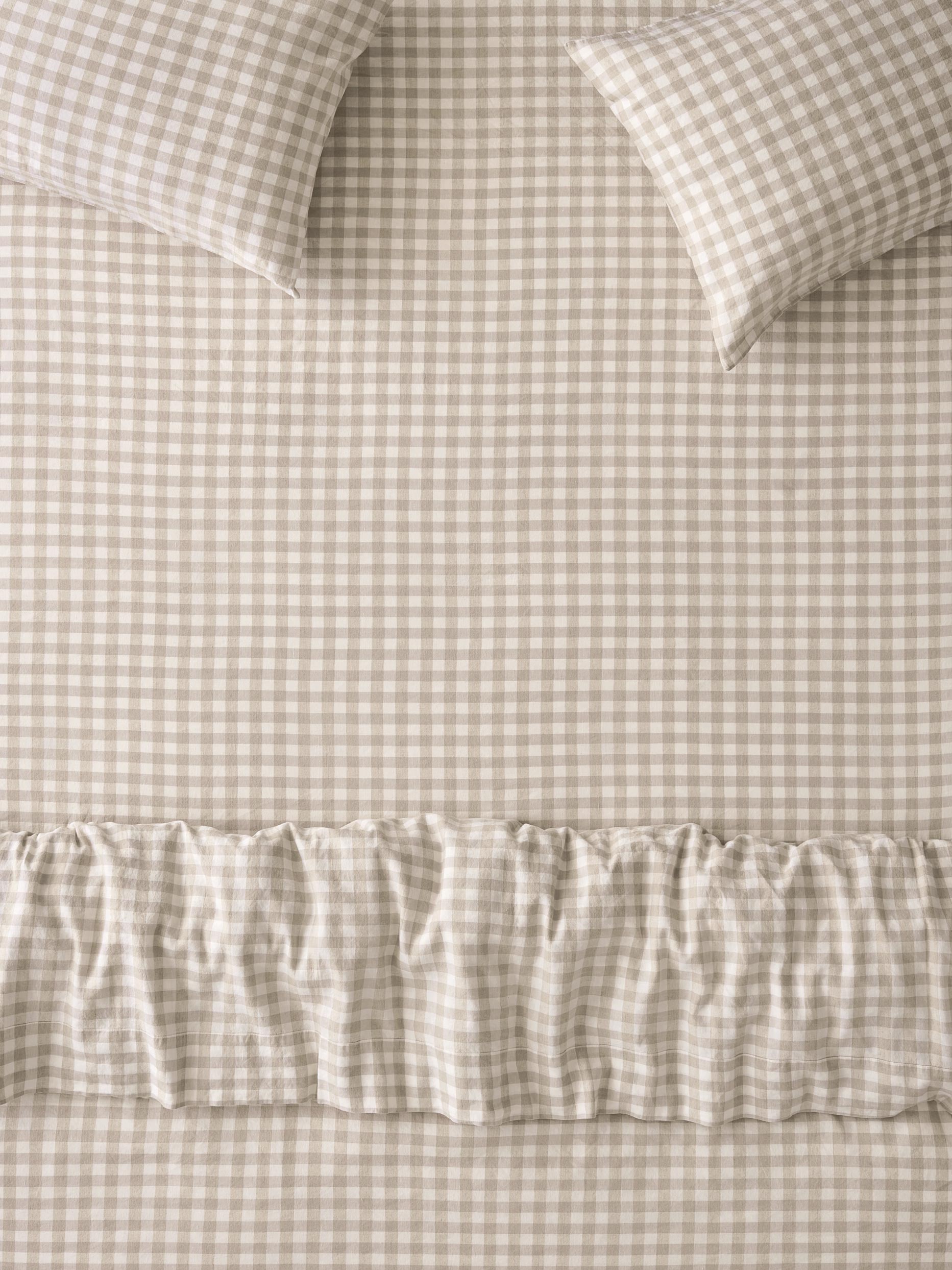 Beige and white gingham check bedding set featuring a sheet, pillowcases, and a ruffled duvet cover.
