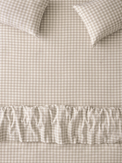 Beige and white gingham check bedding set featuring a sheet, pillowcases, and a ruffled duvet cover.