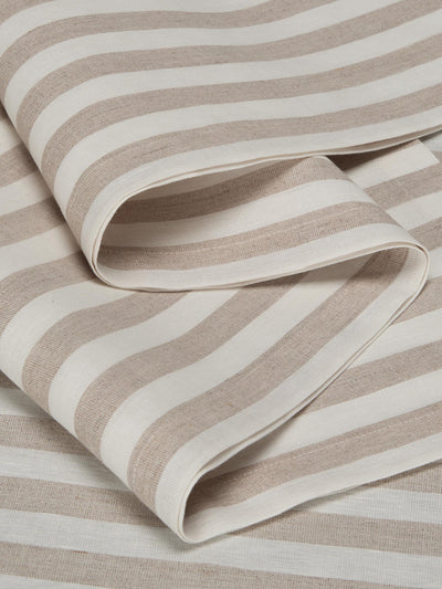 A close-up of folded striped fabric with alternating warm beige and off-white horizontal bands, showing a soft woven texture.