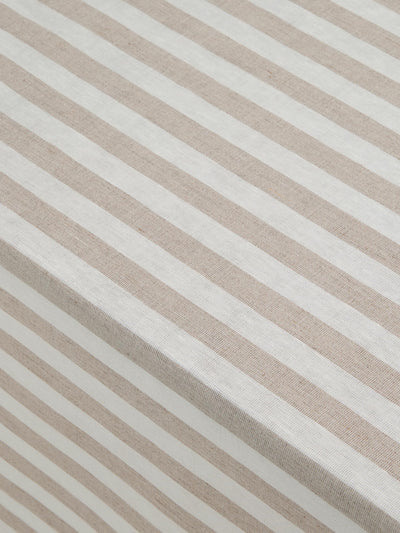 Close-up of a striped fabric with alternating warm beige and off-white diagonal stripes.