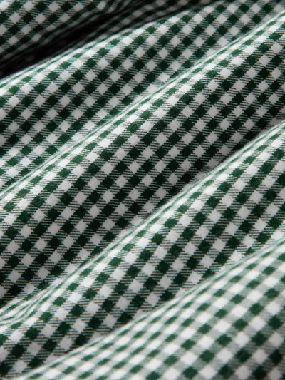 A close-up of a green and white checkered fabric with a textured woven pattern and soft folds.