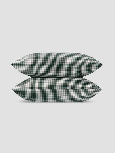 Two rectangular throw pillows stacked vertically, featuring a small-scale black and white gingham check pattern, set against a solid light gray background.