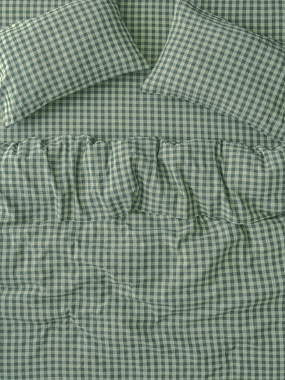 Green and white gingham check bedding set including a comforter and two matching pillowcases, shown in a close-up flat-lay view.