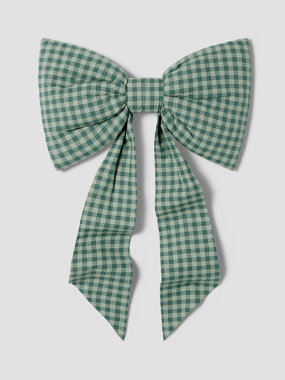 A large fabric bow in a green and white gingham check pattern, photographed flat against a light gray background.