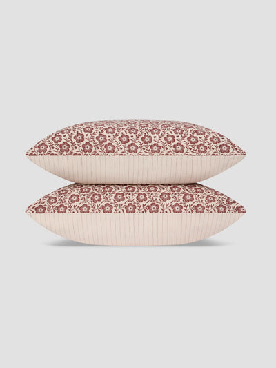 Two decorative throw pillows stacked vertically on a light gray background. The pillows feature a dusty rose floral pattern on the top half and a solid pale blush pink ribbed fabric on the bottom half.