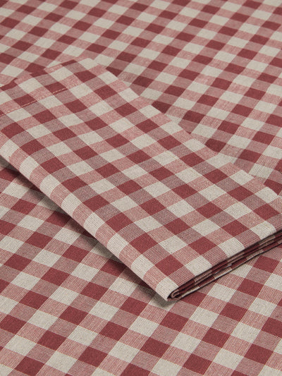 A close-up of folded and flat-laid red and off-white gingham checkered fabric, showing its woven texture and pattern.