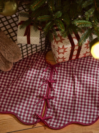 Rhubarb Gingham Linen Blend Tree Skirt with gifts on top under the christmas tree.