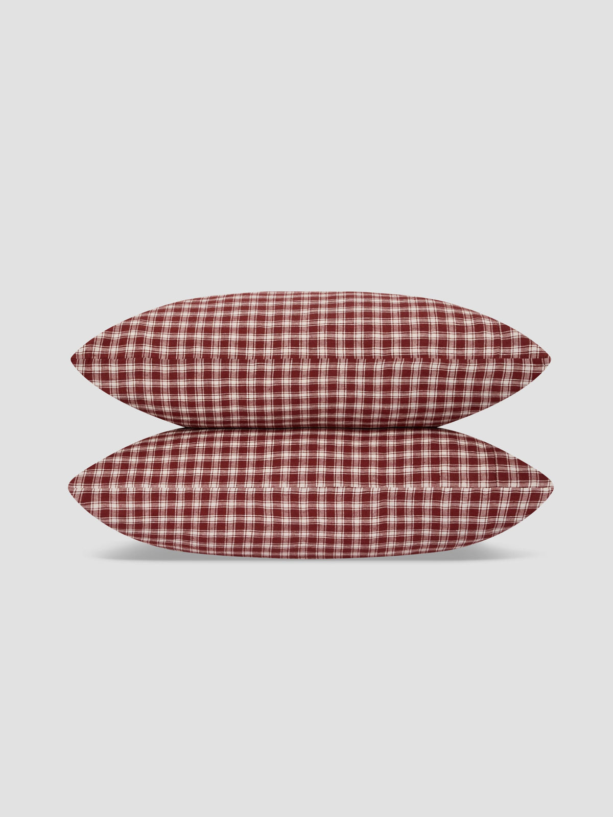 Two rectangular pillows with a red and white gingham check pattern, stacked vertically on a light gray background.