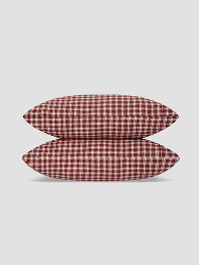 Two rectangular pillows with a red and white gingham check pattern, stacked vertically on a light gray background.