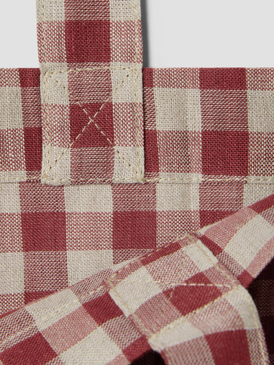 Close up of a rhubarb and oatmeal gingham tote bag.