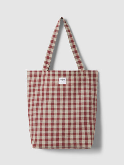 A rhubarb and oatmeal gingham tote bag on a light grey background. 