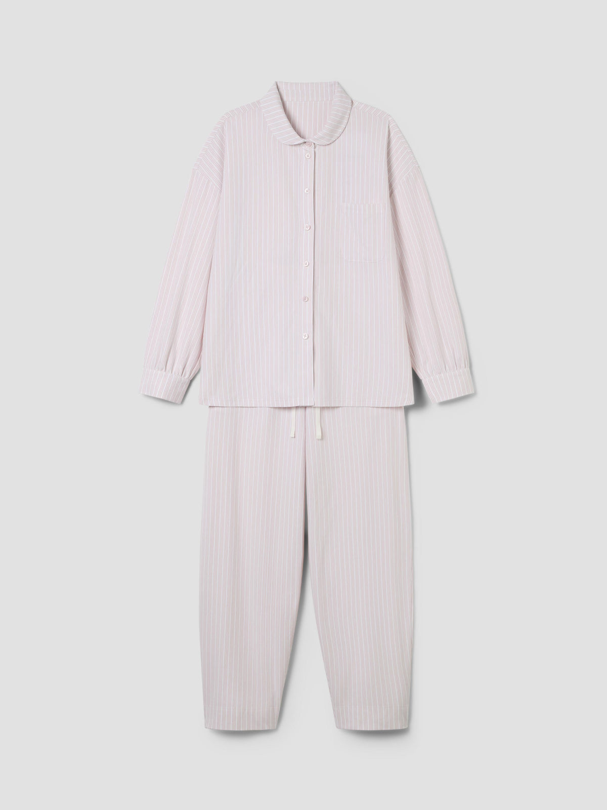 A two-piece pajama set in a very pale pink and white vertical stripe fabric, featuring a long-sleeve button-front top with a collar and matching pants, displayed on a neutral light gray background.