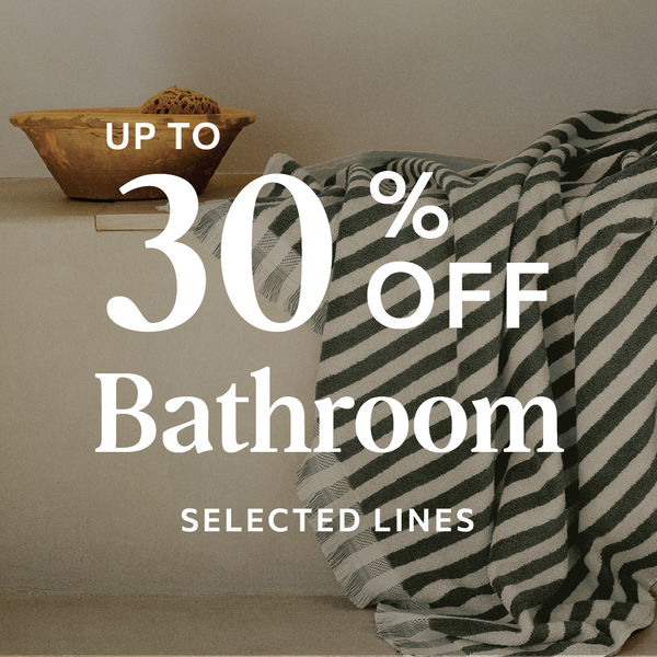 Promotional text for bathroom selections with a striped towel and wooden bowl on a neutral background