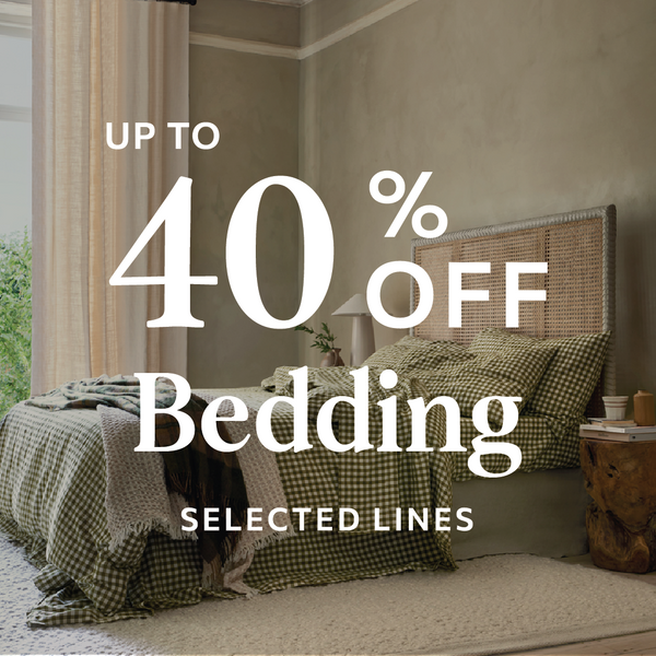 Bedroom with checkered bedding and promotional text for bedding sale.