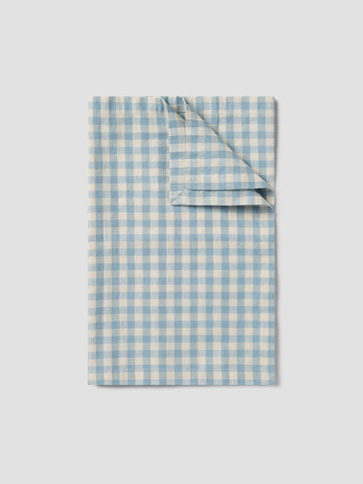 Folded blue and white checkered fabric on a light gray background