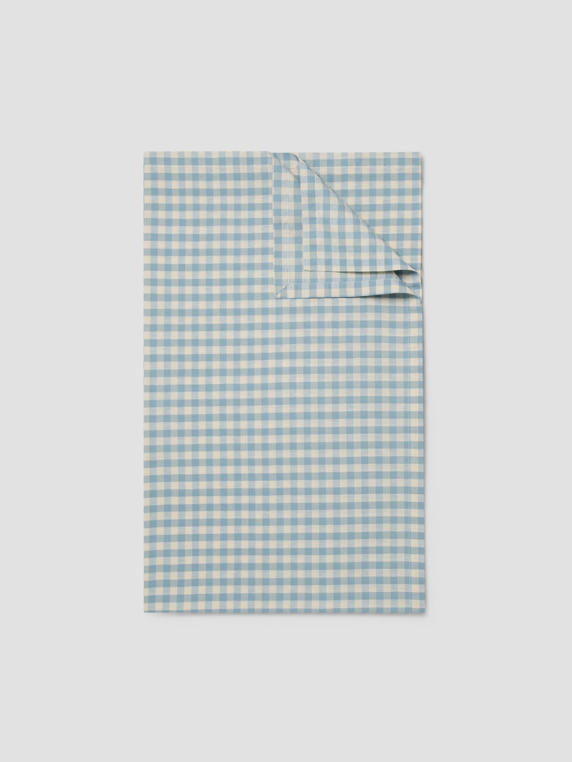 Folded blue and white checkered fabric on a light gray background
