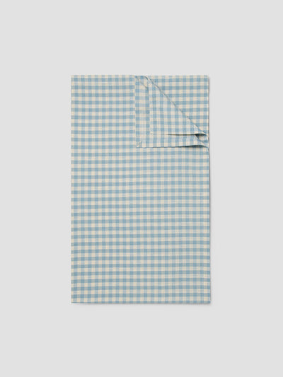 Folded blue and white checkered fabric on a light gray background