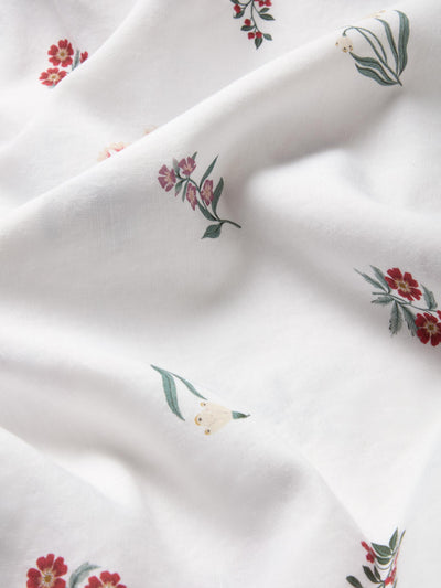 Close up of white fabric with a subtle floral print. 