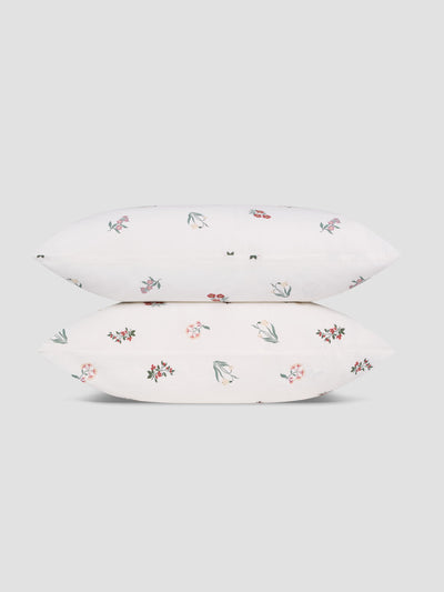 Two white pillows with a subtle floral print stacked on top of each other. 